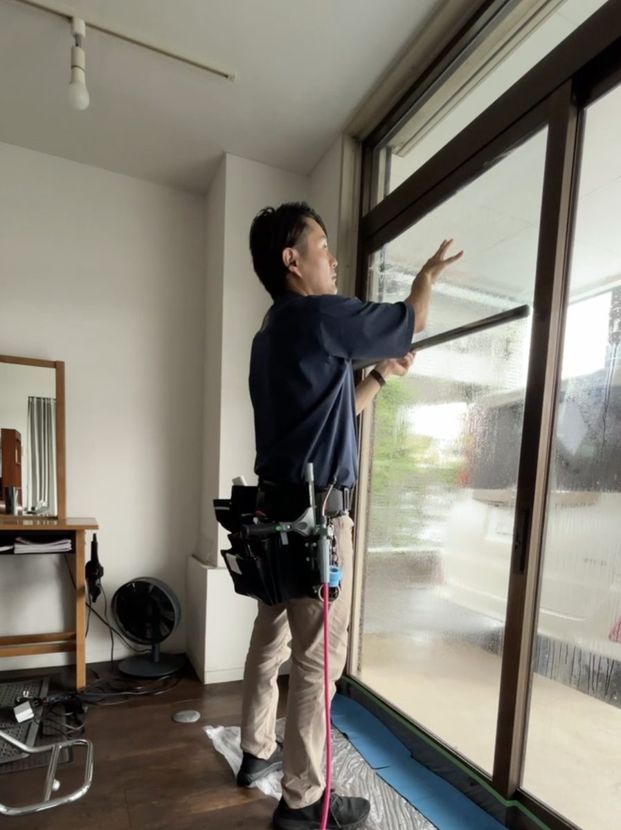 窓ガラスフィルムを施工している職人の様子